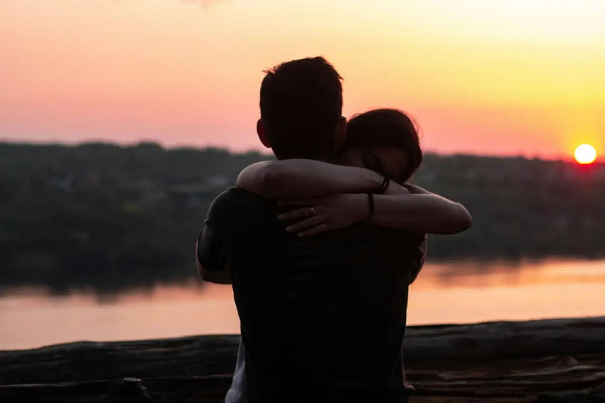 Un couple s'enlace au coucher du soleil