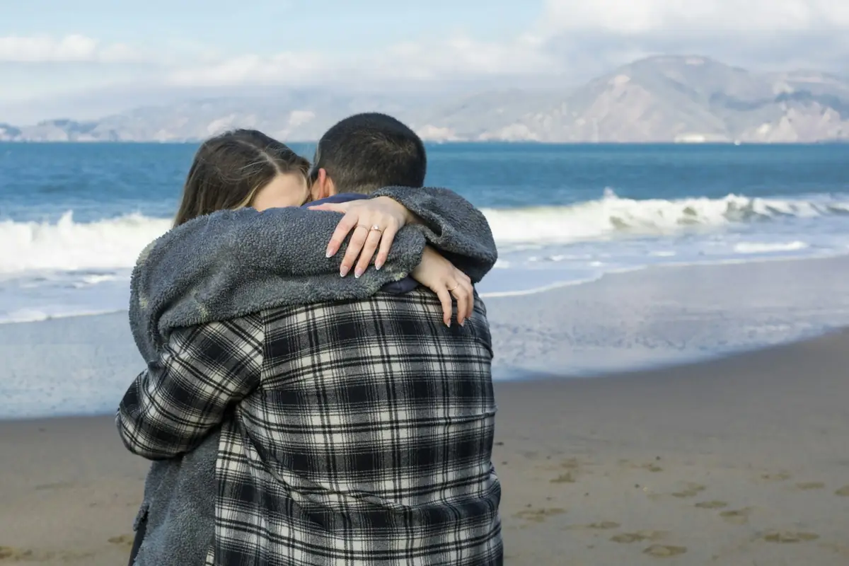 Un couple s'enlace sur une plage